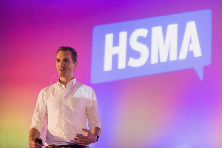 Tobias Koehler auf der Bühne vor dem HSMA Logo